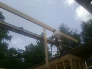Carpenter setting a ridge beam over a new addition frame — Ice Dam Removal by Roofing Brothers in South Thomaston