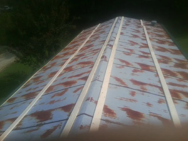Rusted metal roof panels with new wood purlins before replacement — Storm Damage Roof Repair in South Thomaston by Roofing Brothers