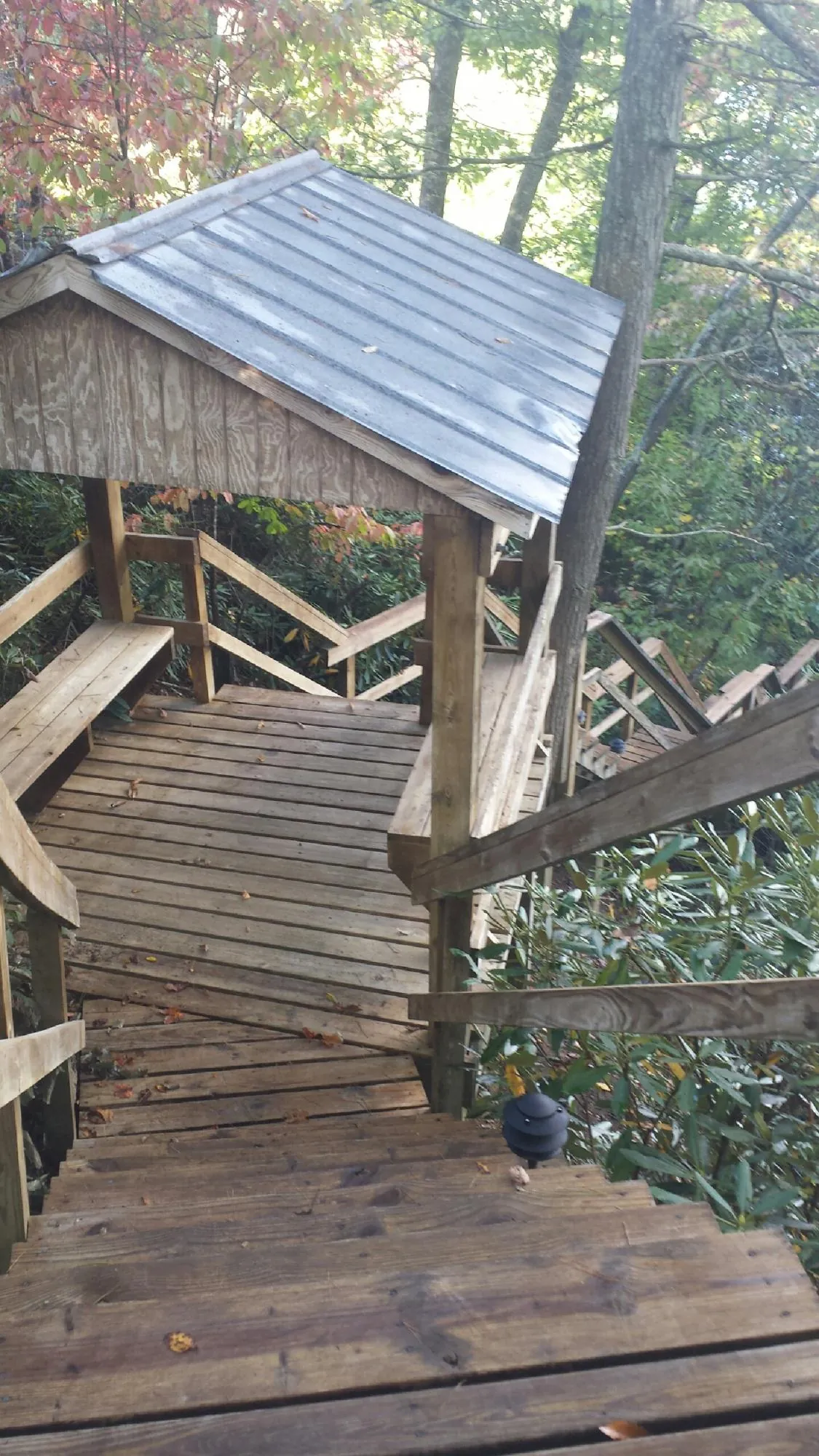 Metal roofed shelter over wooden steps on a wooded walkway — Skylight Repair & Installation work by our crew in South Thomaston